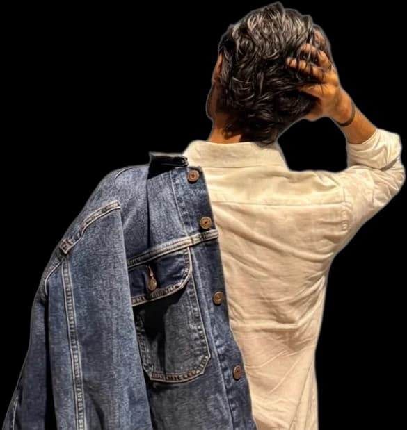 Satnam, seen from behind with one hand in their hair and a denim jacket over one shoulder.